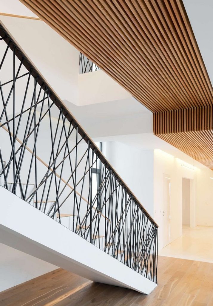 Stahltreppe mit extravagantem Stahlgeländer, Handlauf aus Holz, Wohnbereich